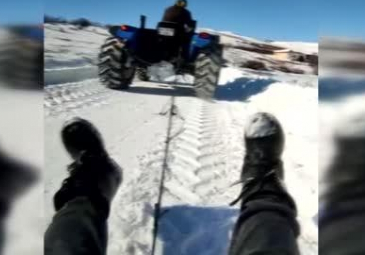 Traktör arkasında karda sörf